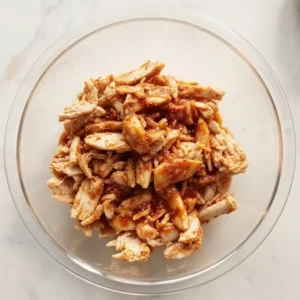 Hot Honey Chicken Quesadillas Recipe 5 mixing shredded chicken with chipotle powder and honey in a bowl